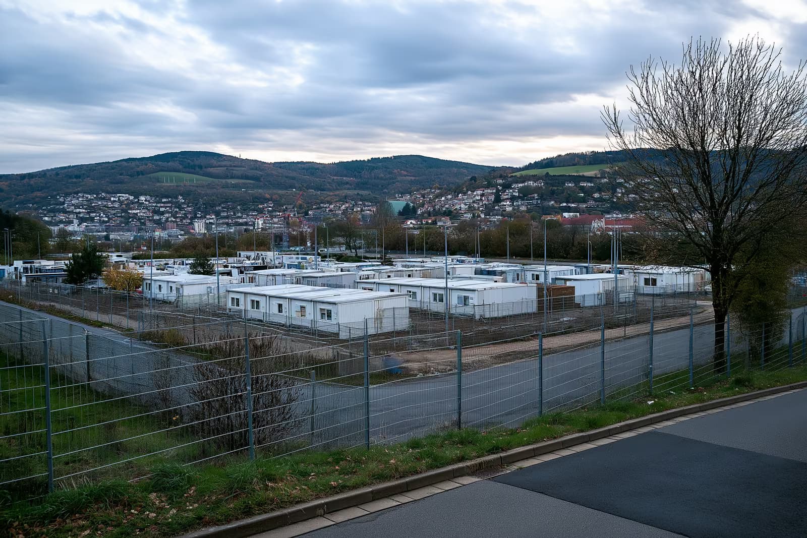 Iežogota izmitināšanas zona ar konteineru ēkām Vācijas pilsētas nomalē.